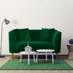 Zielona sofa dwuosobowa stoi w salonie